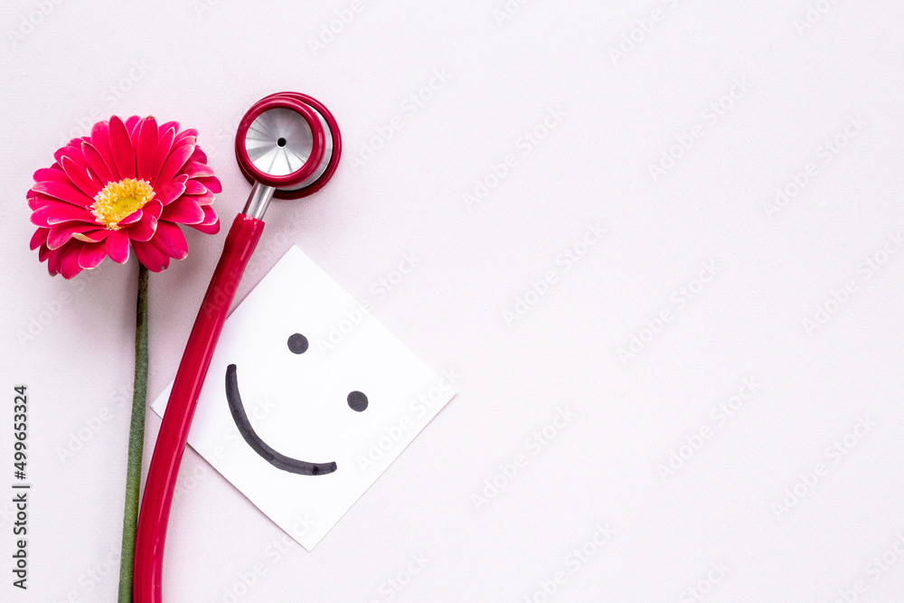 Breast cancer awareness concept with red flower and stethoscope Breast cancer awareness concept with red flower and stethoscope