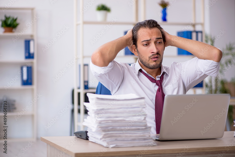 Fototapeta premium Young male employee and too much work in the office