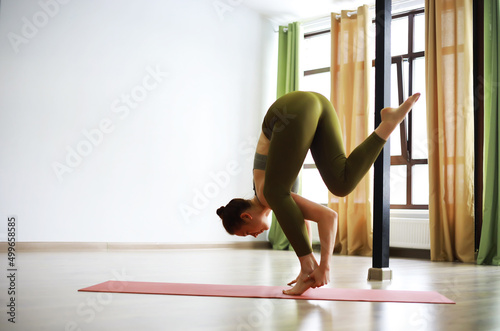 Attractive woman with perfect body in a sports clothes standing in a yoga pose. Concept of sports healthy lifestyle, nutrition and training workout.