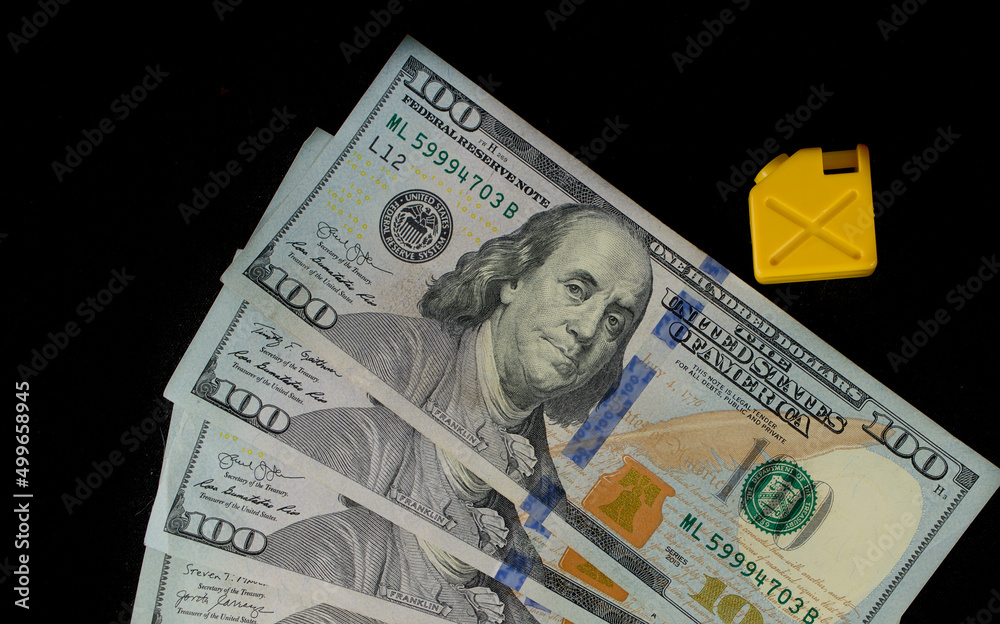 Fuel canister and dollar banknotes on black background Fuel canister and dollar banknotes on black background