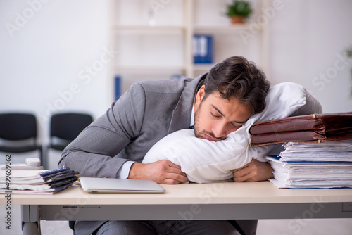 Young male employee in oversleeping concept