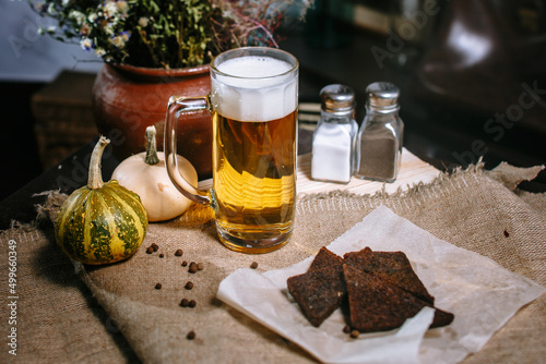 Beer in a large mug, standing on the table. Fried toast from black bread in a plate. photo