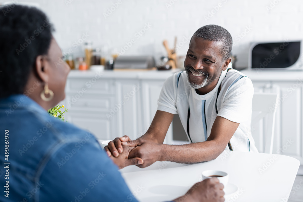 Fototapeta premium senior african american man smiling and holding hands with wife.