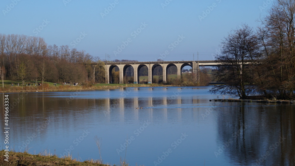 Obraz premium railway bridge over the lake on a spring evening in a city in Germany