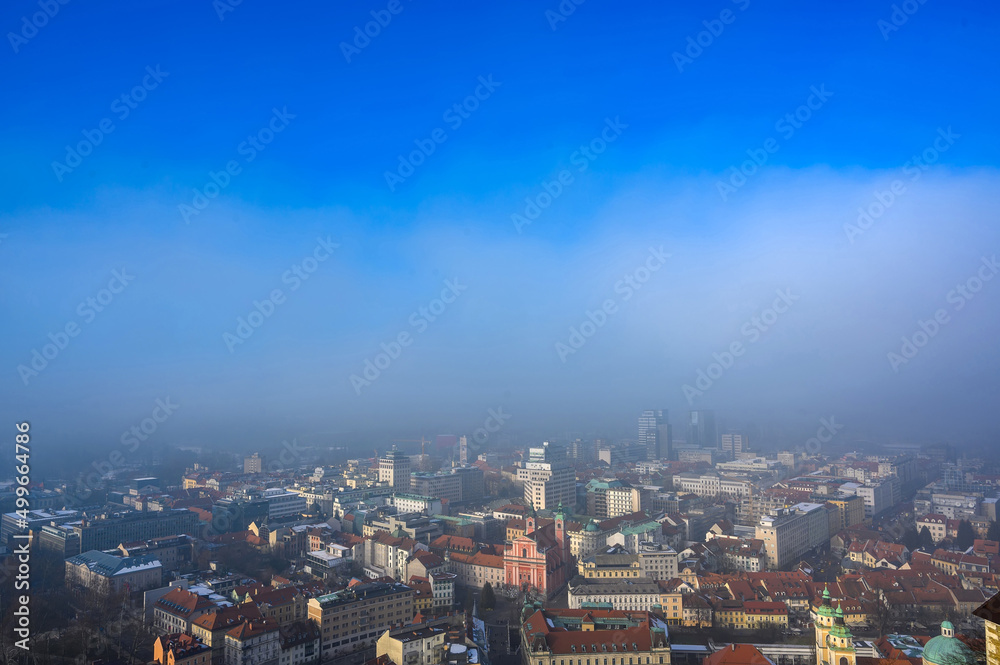 Landscape view on the Ljubljana city from the castle during a windy foggy sunny weather in the winter