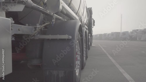 Tanker truck in the parking lot, rear view. large white tank truck in a factory, Isothermal Tank truck driving on highway. Oil and Gas Transportation and Logistics. Metal chrome cistern tanker with pe