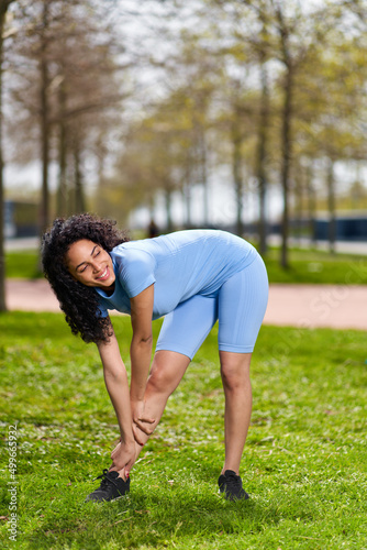 afro girl blue sportswear on sports in the park © JENOCHE