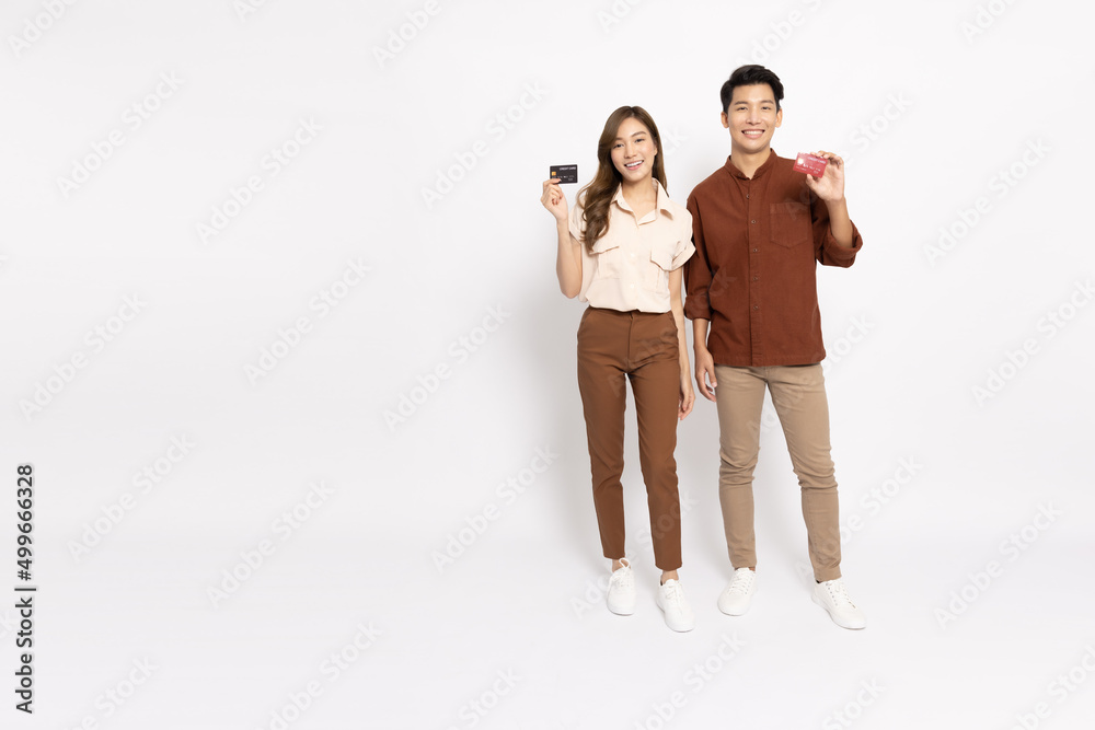 Young Asian couple smiling, showing and presenting credit card for paying online business isolated on white background Young Asian couple smiling, showing and presenting credit card for paying online business isolated on white background