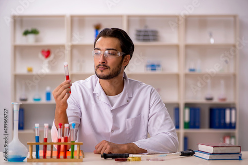 Young male chemist working at the lab