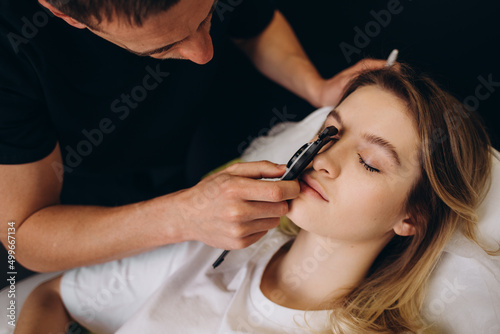 Young woman having meeting with plastic surgeon