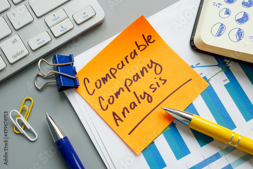 A comparable company analysis CCA report and notepad.