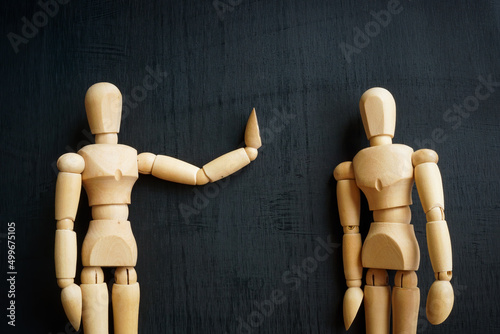 Assertiveness and confidence concept. Two wooden figurines on the dark surface.
