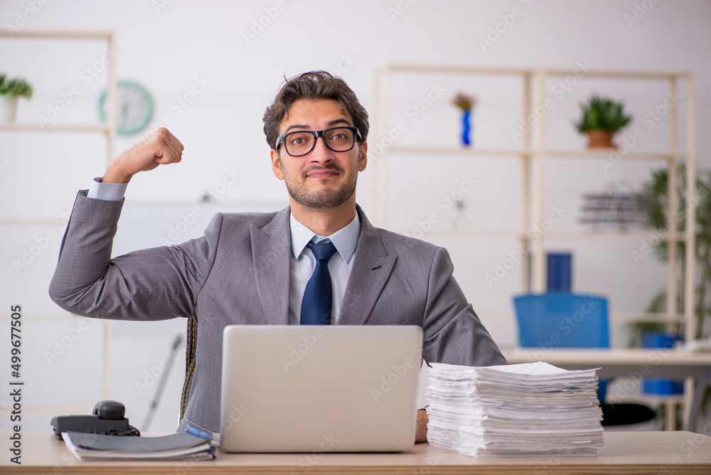 Young male employee sitting at workplace Young male employee sitting at workplace