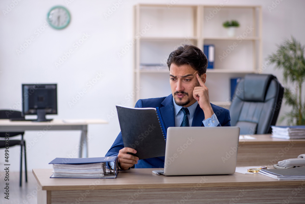 Young male employee working in the office Young male employee working in the office