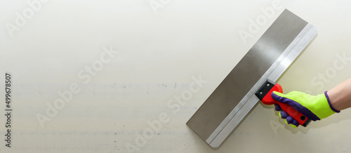 Canvastavla Clean Spatula in a male hand in a bright glove against a gray wall