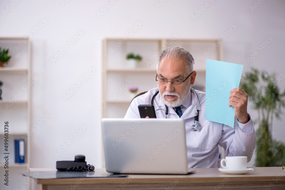 Old male doctor in telemedicine concept Old male doctor in telemedicine concept