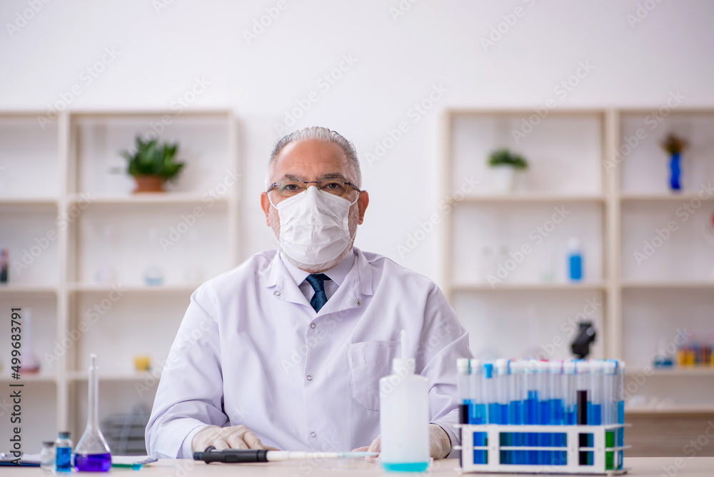 Old male chemist working at the lab Old male chemist working at the lab