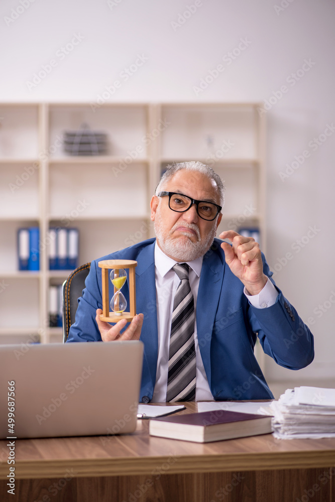 Old male employee in time management concept Old male employee in time management concept