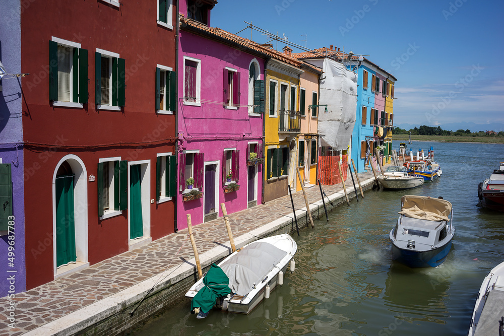 Fishing motor boat and traditional colorful houses on the Burano island - one of attractive tourist objects in the Venetian lagoon