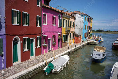 Fishing motor boat and traditional colorful houses on the Burano island - one of attractive tourist objects in the Venetian lagoon