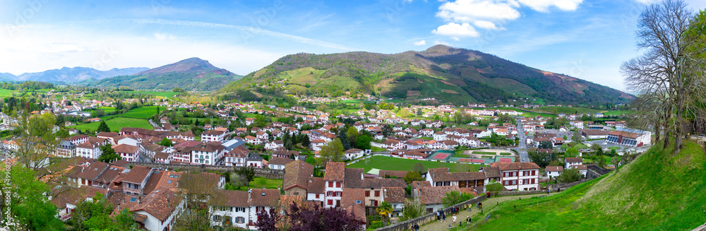 Panoramic view of Saint Jean Pied de Port village, in France. Beautiful villa next to the mountains on a clear day and some clouds decorating the sky. Horizontal photography.