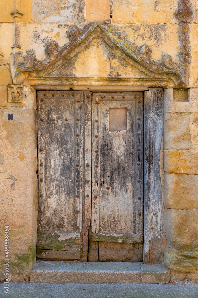 Wooden door on an ancient stone building Wooden door on an ancient stone building