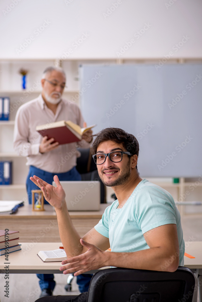 Obraz premium Old male teacher and young male student in the classroom
