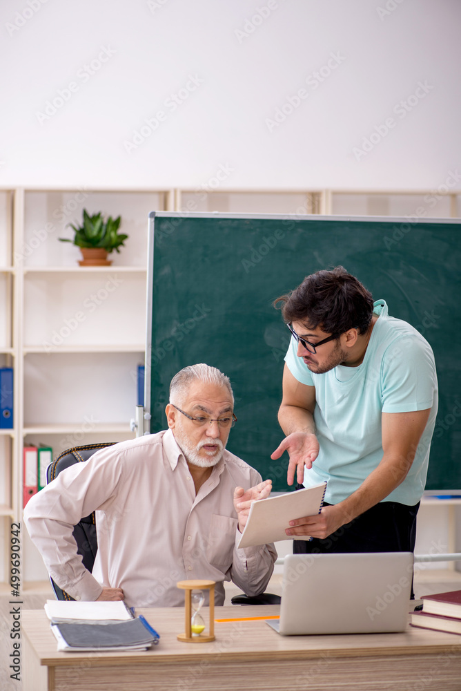 Obraz premium Old male teacher and young male student in the classroom