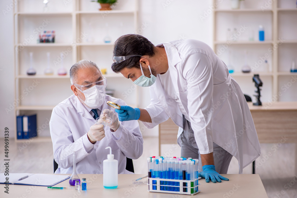 Two male chemist working at the lab Two male chemist working at the lab