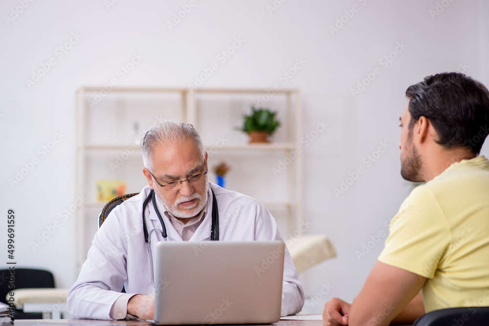 Obraz premium Young male patient visiting old male doctor