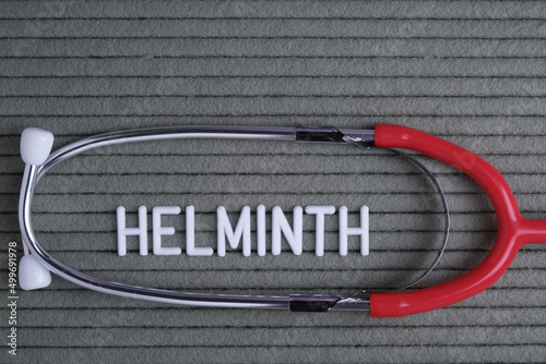 helminth - text from white letters on  green background with  stethoscope, medical concept diagnostics. photo