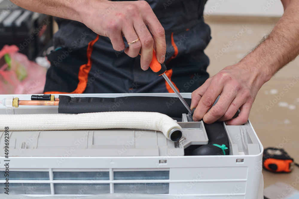 Worker installs indoor unit of the air conditioner. Man preparing to install new air conditioner. Worker installs indoor unit of the air conditioner. Man preparing to install new air conditioner.