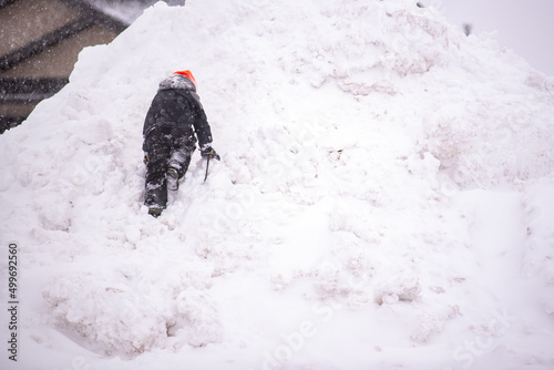 kid climbing a snow pile