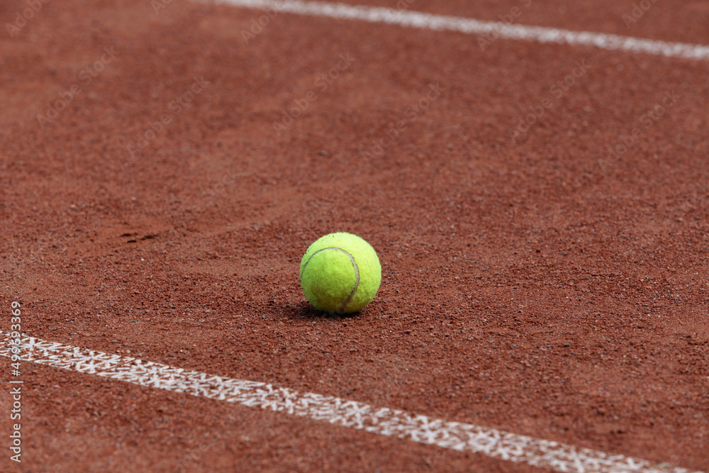 Tennis ball on outdoor clay tennis court. Selective focus, copy space. Design element