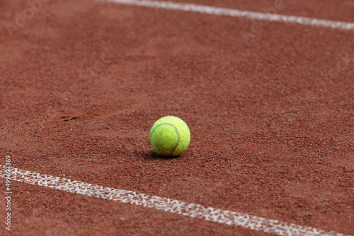 Tennis ball on outdoor clay tennis court. Selective focus, copy space. Design element © AB-7272