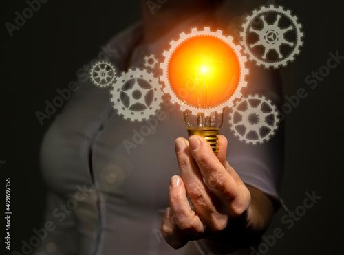 New technology development and innovation concept, engineer in hand holding light bulb with gears icons