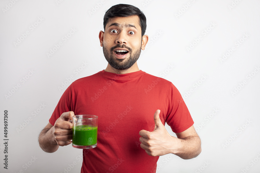 wheat grass juice drinking by a young handsome indian men wheat grass juice drinking by a young handsome indian men