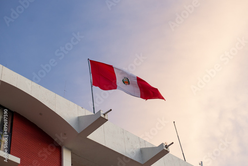 Bandera nacional de Peru flameando con un cielo de color. photo