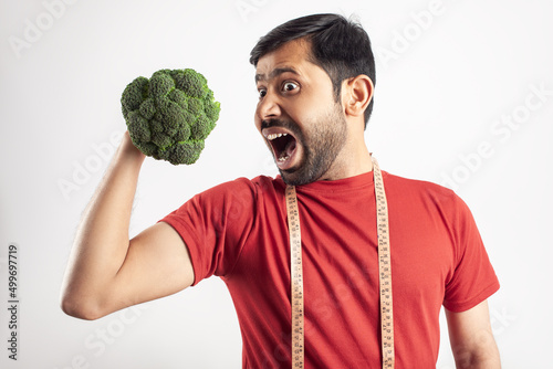 slim fit man love to eat broccoli for healthy dieting