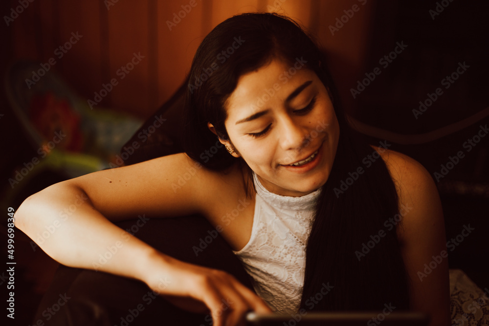Chica trabajando en su tableta mientras descansa en casa. Chica trabajando en su tableta mientras descansa en casa.