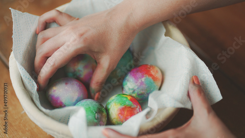 Easter Eggs decoration, hands showing decorations on Easter eggs placed in basket on wooden table 05