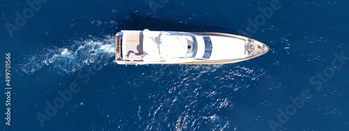 Aerial drone ultra wide panoramic photo of small luxury yacht cruising in deep blue sea near Aegean island, Greece