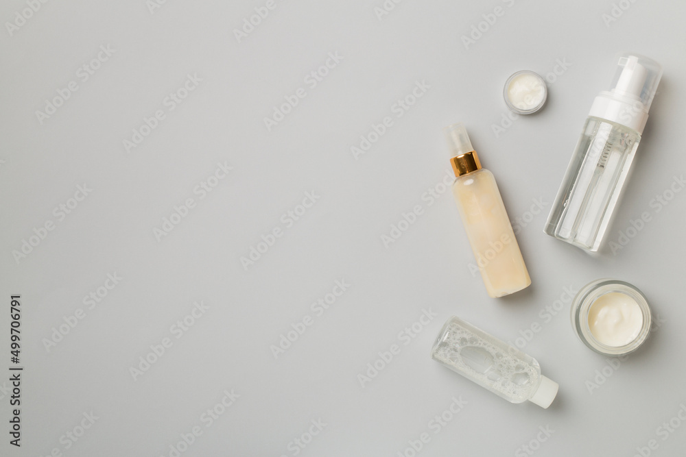 Different cosmetic bottles on color background, top view Different cosmetic bottles on color background, top view