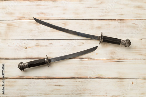 Cossack saber on wooden background, top view photo