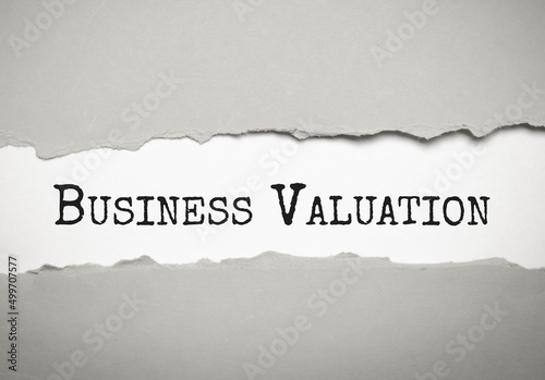 Business Valuation. text on white torn paper on blue background