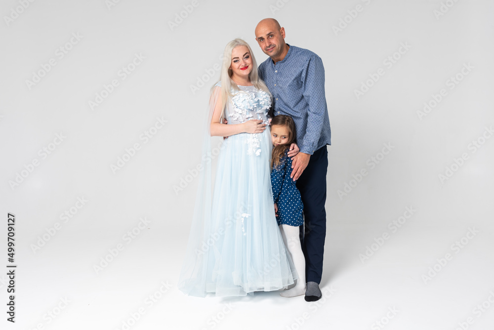 Beautiful pregnant woman with her family on light background Beautiful pregnant woman with her family on light background