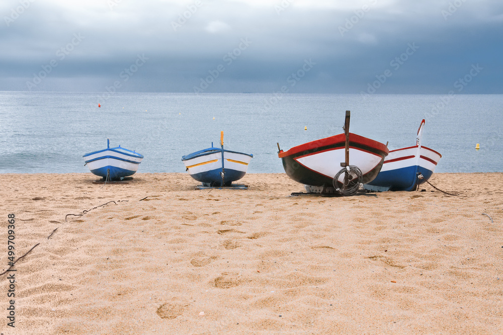 The moment before the storm. Four old fishing boats in Calella, Spain