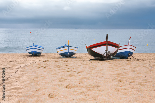 Obraz na płótnie The moment before the storm. Four old fishing boats in Calella, Spain w salonie