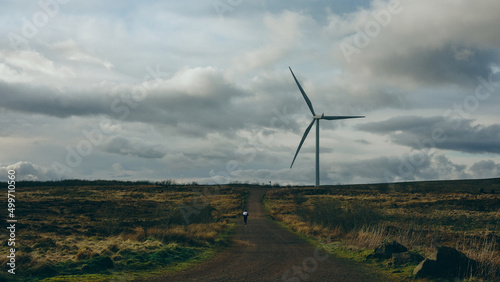 woman running near wind turbine in the field photo