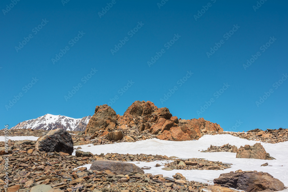 Scenic mountain landscape with old rocks and stones among snow in sunlight. Awesome alpine scenery with stone outliers on high mountain under blue sky in sunny day. Sharp rocks at very high altitude. Scenic mountain landscape with old rocks and stones among snow in sunlight. Awesome alpine scenery with stone outliers on high mountain under blue sky in sunny day. Sharp rocks at very high altitude.